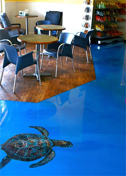 A sea turtle was painted on this concrete floor that has been covered with blue epoxy.