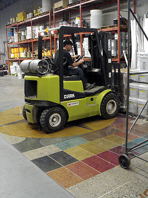 Forklift moving over the top of polished and dyed concrete floor.
