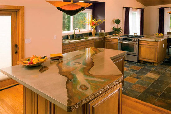 Concrete countertop on an island in a kitchen brings in a natural river aspect in colors and design.